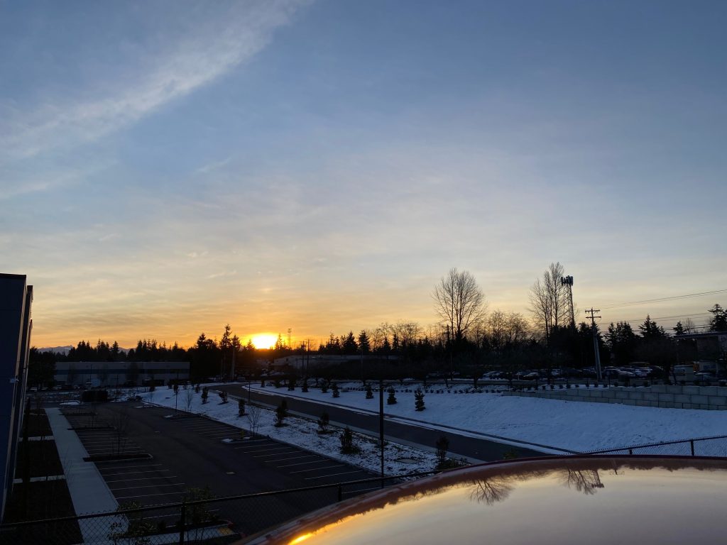 sunrise over an empty car park with wispy clouds overhead
